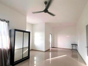 a living room with a ceiling fan and a mirror at Caro Home in Malacca