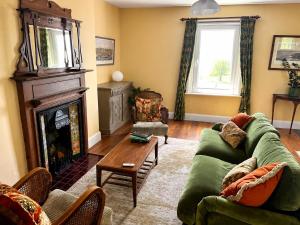 a living room with a green couch and a fireplace at Stylish Top Floor Retreat with Stunning Solent Views in Portsmouth