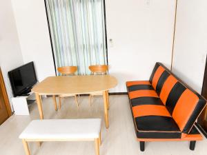 a living room with a table and a chair at 宿のきむら2 in Utsunomiya