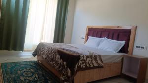 a bedroom with a bed with a wooden headboard at Hotel Turi & Punjabi Restaurant in Rewalsar