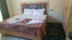 a bedroom with a large bed with towels on it at Hotel Turi & Punjabi Restaurant in Rewalsar