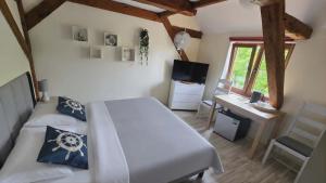 a bedroom with a bed and a desk and a window at Pokoje Gościnne w Spichlerzu in Ustka
