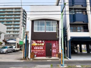 a building with a red door on a city street at 宿のきむら2 in Utsunomiya