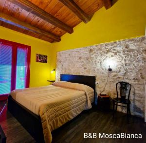 a bedroom with a bed and a stone wall at B&B Mosca Bianca in Ascoli Piceno