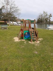 a playground in a park next to the water at Gite du Canal in Gannay-sur-Loire +8 photos