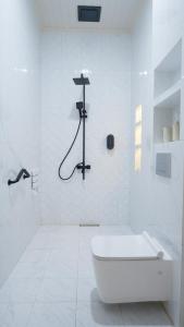 a white bathroom with a tub and a shower at Villa Dalia Puncak EE11-24 in Cikujang +20 photos