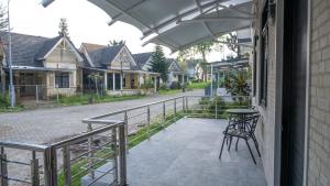 a balcony with a table and chairs on a house at Villa Dalia Puncak EE11-24 in Cikujang