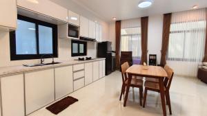 a kitchen with a table and a dining room at Villa Dalia Puncak EE11-24 in Cikujang