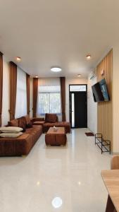 a large living room with couches and a flat screen tv at Villa Dalia Puncak EE11-24 in Cikujang
