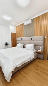 a bedroom with a large bed with white sheets at Villa Dalia Puncak EE11-24 in Cikujang