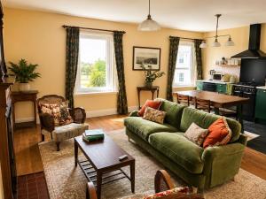 a living room with a green couch and a table at Stylish Top Floor Retreat with Stunning Solent Views in Portsmouth