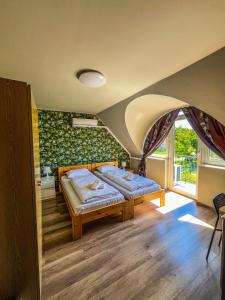 a bedroom with two beds in a room at Zöldház Panzió in Gyenesdiás +44 photos