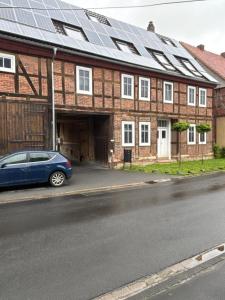 a car parked in front of a building with solar panels at Allenberghütte Schoningen in Uslar