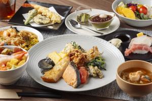 a table with plates of food and bowls of food at Richmond Hotel Sapporo Odori in Sapporo