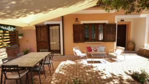 a patio with a wooden table and chairs at Laurus Home Restaurant B&B Cilento in Trentinara