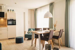 a kitchen and dining room with a table and chairs at Am Park 16 in Prerow