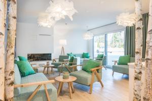 a living room with green chairs and a fireplace at Am Park 16 in Prerow +7 photos