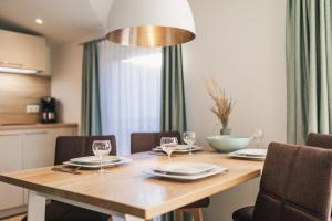 a dining room table with chairs and a light fixture at Am Park 25 in Prerow