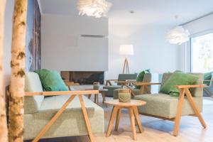 a living room with couches and tables at Am Park 25 in Prerow +7 photos