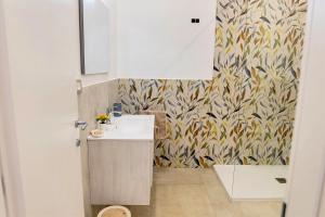 a bathroom with a sink and a wall at Gea Guest House in Syracuse