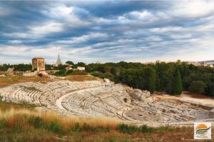 an ancient amphitheater on a hill with a city at Gea Guest House in Syracuse