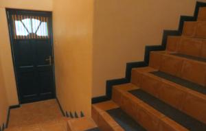 a stairway with a black door and a window at Durbanville Place - 3 bedroom apartment in Durbanville