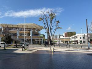 a person standing in a plaza in front of a building at Shonan Beach&Sun in Chigasaki