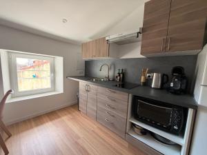 a kitchen with a sink and a microwave at Le Cocon du théâtre Clim Hyper centre in Orange +10 photos
