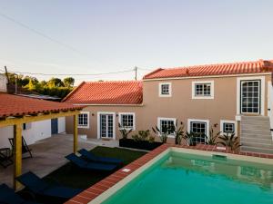 a villa with a swimming pool and a house at Casas dos Amigos in Bom Sucesso