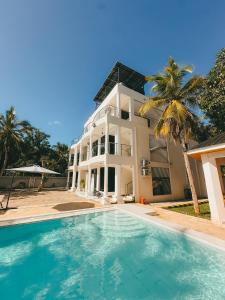 a house with a swimming pool in front of it at Serian Breeze 6 Bedroom Villa Diani in Ukunda