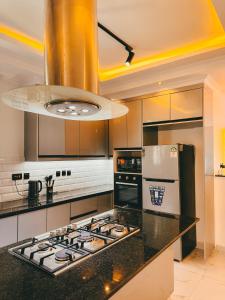a kitchen with a stove top oven and a refrigerator at Serian Breeze 6 Bedroom Villa Diani in Ukunda