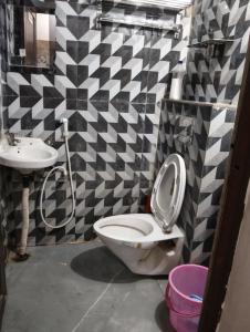 a bathroom with a toilet and a sink at BHS Deluxe Rooms in Puri