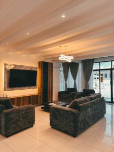 a living room with two couches and a flat screen tv at Serian Breeze 6 Bedroom Villa Diani in Ukunda