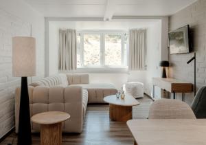 a white living room with a couch and a table at Duindomein Ter Helme in Oostduinkerke