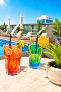 two cocktails on a table next to a pool at Carlton Downtown Hotel in Dubai