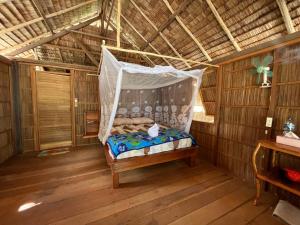a room with a hammock in a hut at Kemmi Homestay Raja Ampat in Merpati