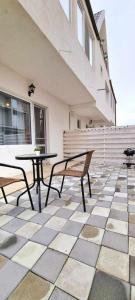 eine Terrasse mit Tisch und Bänken an einem Gebäude in der Unterkunft Studiouri Techirghiol in Techirghiol