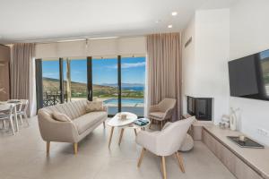 a living room with a couch and chairs and a tv at Villa Elliopetra - Adults Only in Vasilikí