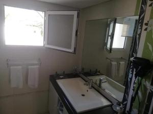 a bathroom with a sink and a mirror at Appartement Hotel Andalucia Bizerte in Bizerte