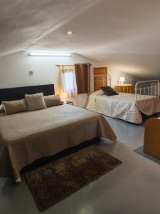 a bedroom with two beds and a rug at Casa Araújo in Mós