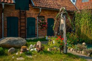 a garden in front of a house with green doors at Steins Hof in Suderburg +2 photos