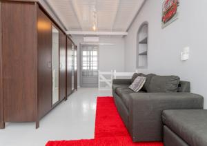 a living room with a couch and a red rug at Bursa Cottage House in Mesochórion