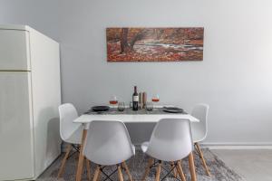 a dining room with a white table and white chairs at Bursa Cottage House in Mesochórion +8 photos