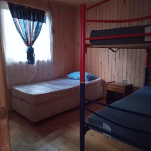 a bedroom with a bunk bed and a window at Posada Kalku in El Tabo