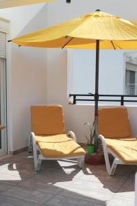 two chairs and an umbrella on a patio at Villa Helia in Kos