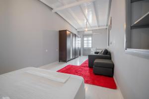 a bedroom with a bed and a couch and a red rug at Bursa Cottage House in Mesochórion