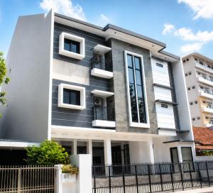 a house with a black and white facade at Djuragan Kamar Labuhan in Semarang