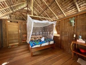a bedroom with a hammock in a room at Kemmi Homestay Raja Ampat in Merpati