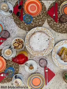 a table with plates of food on it at B&B Mosca Bianca in Ascoli Piceno
