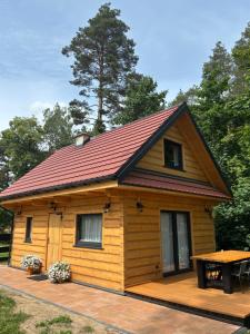 a log cabin with a table on a deck at Chata u Drwala Święta Lipka in Święta Lipka